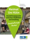 Cover des Kartenflyers zur Ausstellung "Heimat Uni Köln" mit einer Ortsmarkierung und einem Foto, das zwei Studentinnen und einen Studenten in einem Treppenhaus zeigt. Der junge Mann sitzt mit einem Laptop auf dem Boden, die beiden Frauen stehen am Geländer und beugen sich über einen Ordner.