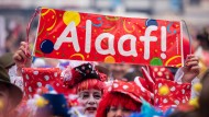 Foto: Kostümierte Menschen mit einem Schild mit der Aufschrift "Alaaf"