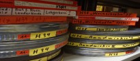 Gestapelte 16mm-Filmrollen mit rot-gelben Aufklebern