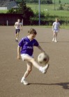 Jungen, die auf einem Sportplatz mit Tor Fußball spielen